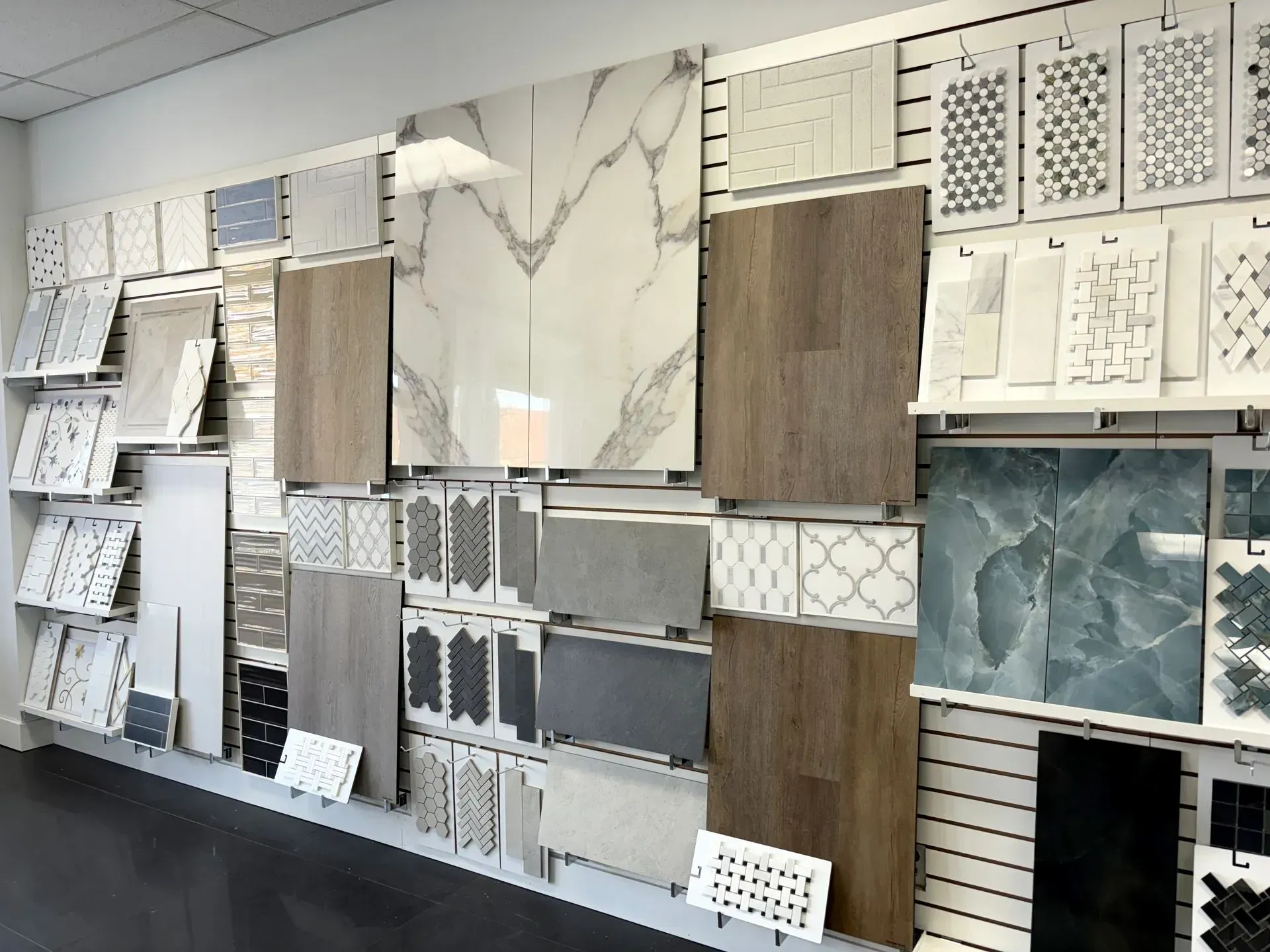 Wall display of tile samples in various colors and patterns for flooring and backsplash selection