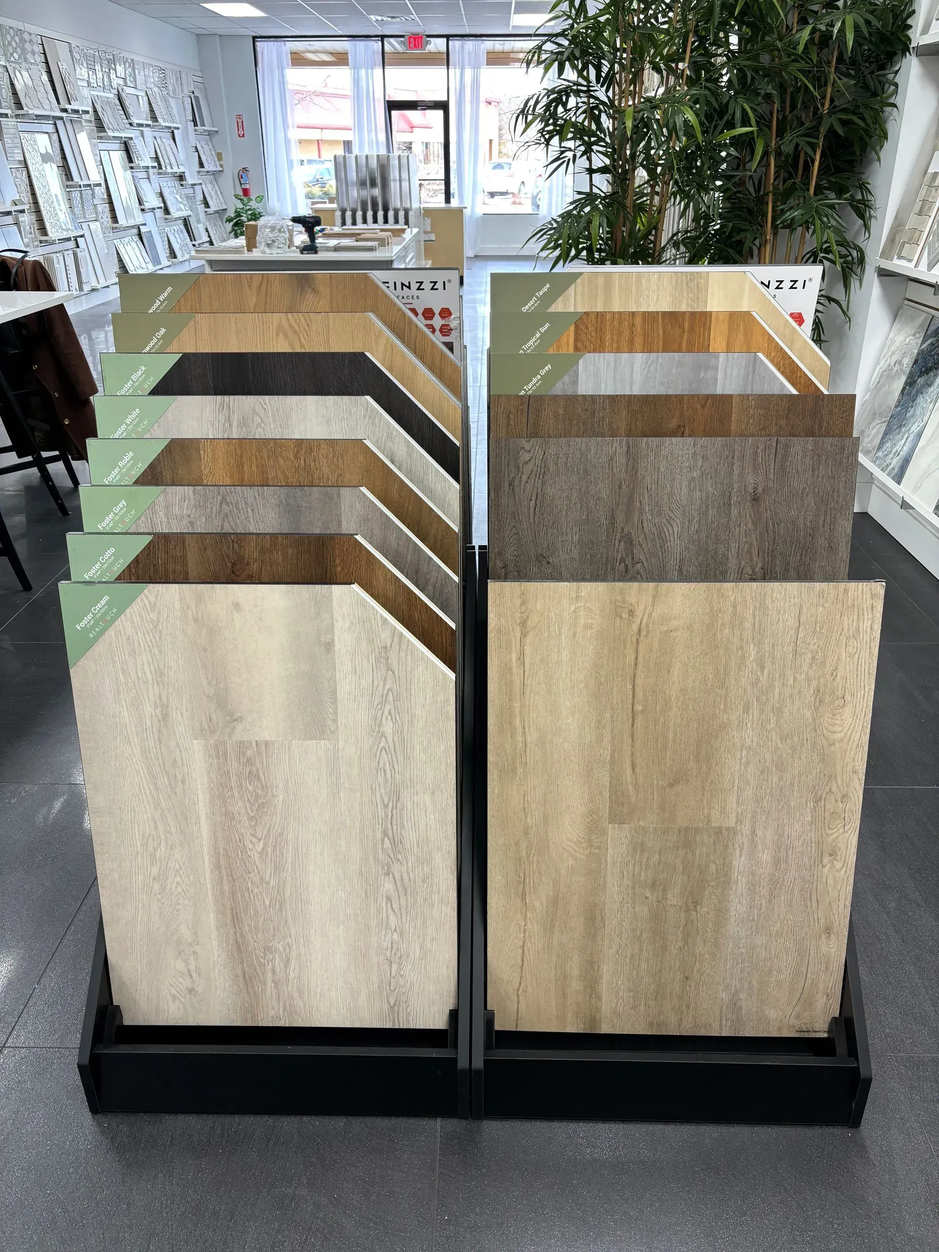 Flooring sample display stand with multiple wood and stone laminate panels in a showroom