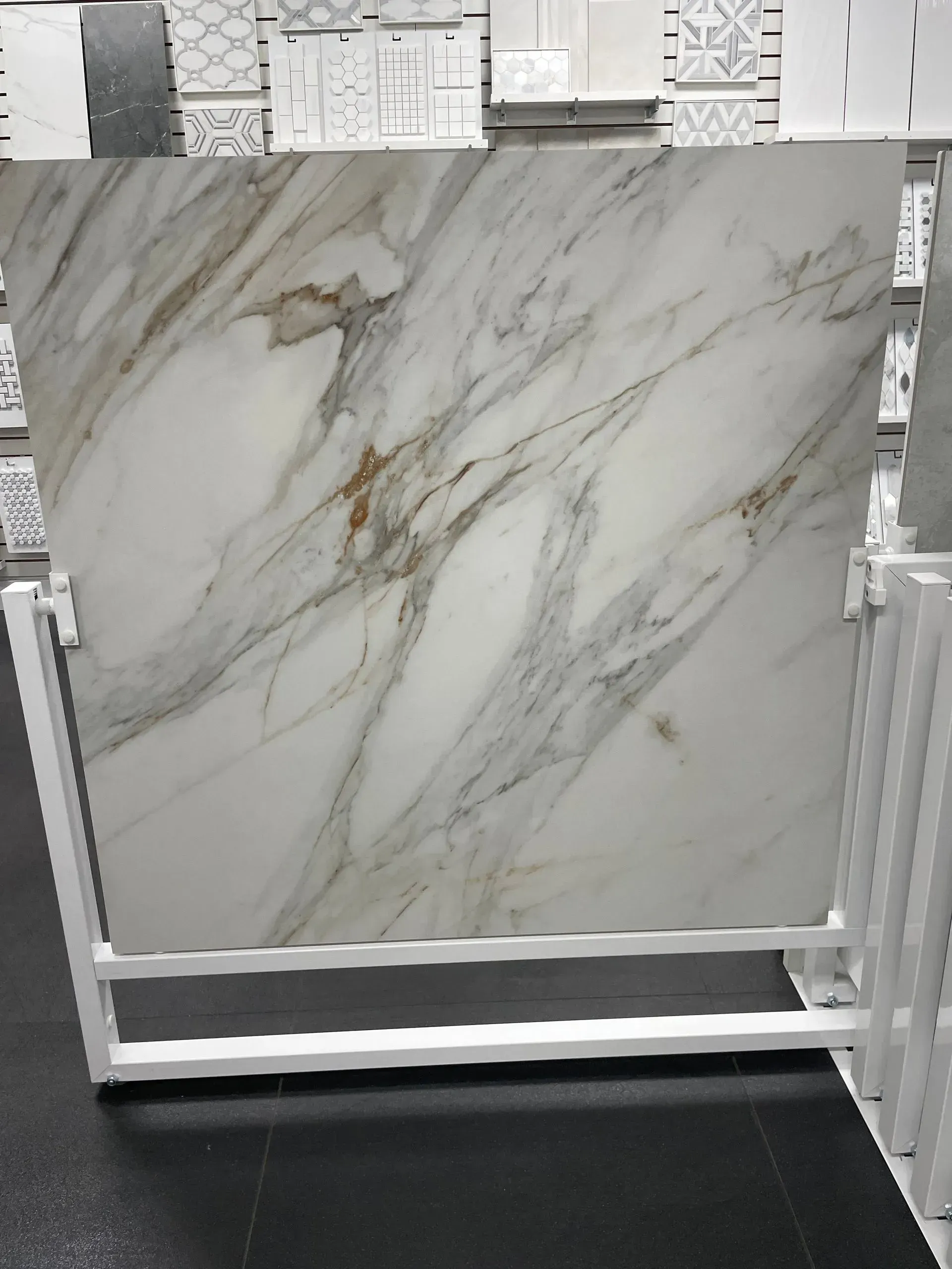 Large white marble-look tile on a white display stand in a showroom