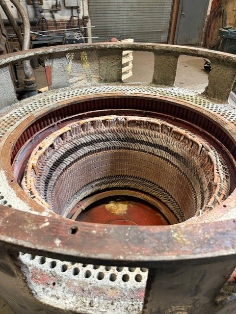Rusty industrial furnace interior with concentric metal rings and a grated outer rim