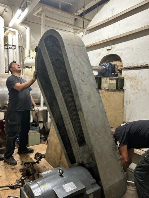 two people working on a huge machinery