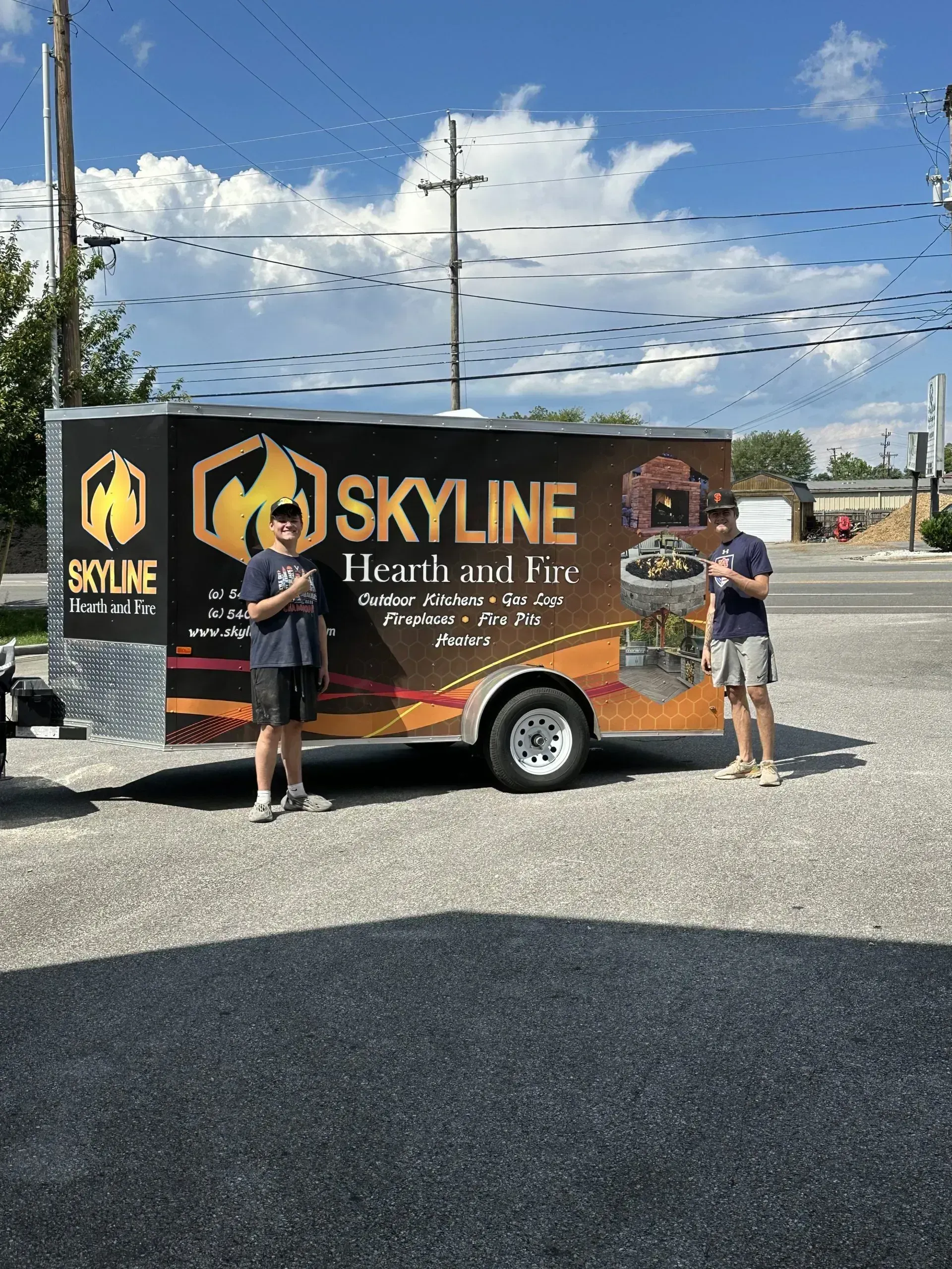 Two people stand next to a trailer with 