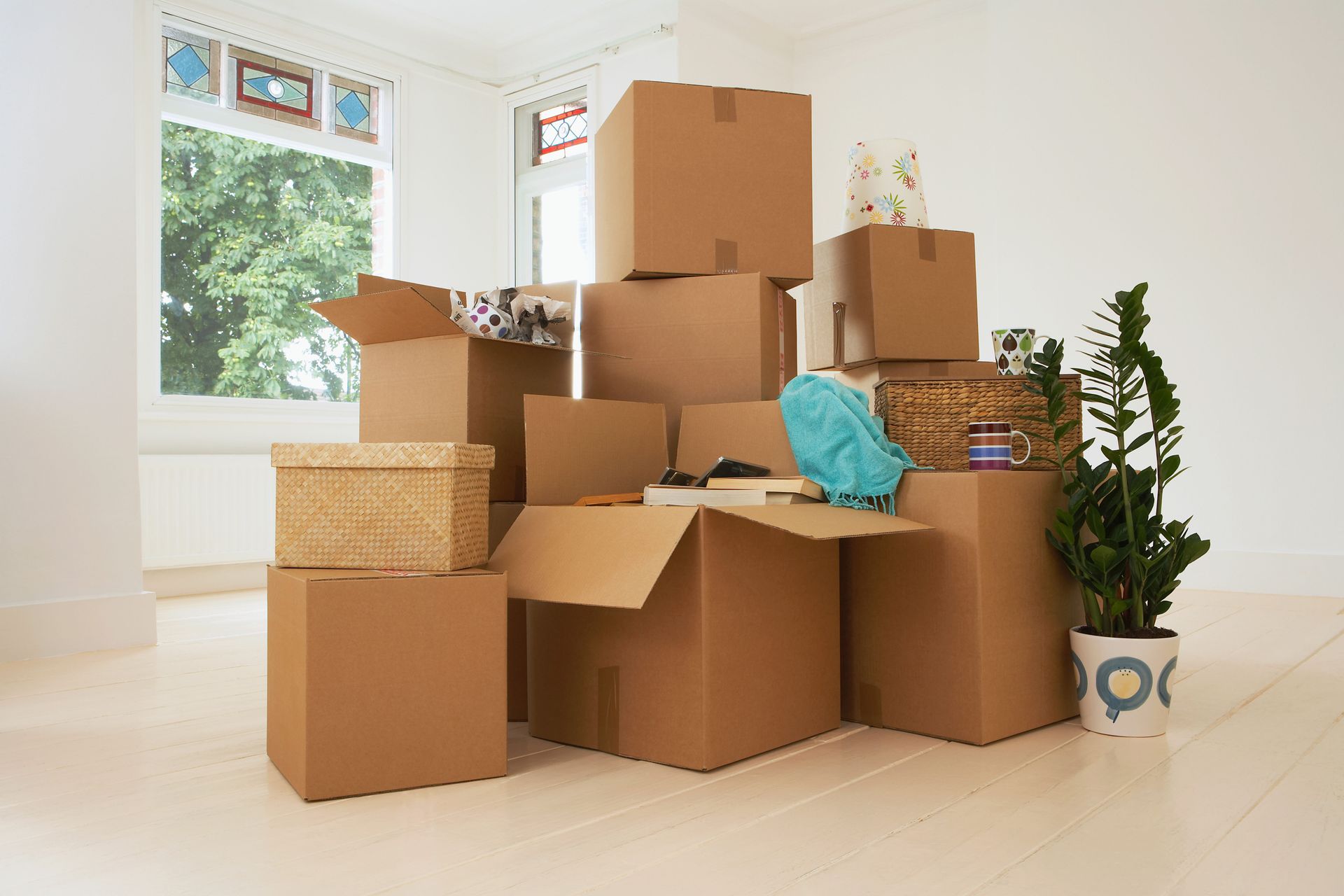 A bunch of cardboard boxes are stacked on top of each other in an empty room.