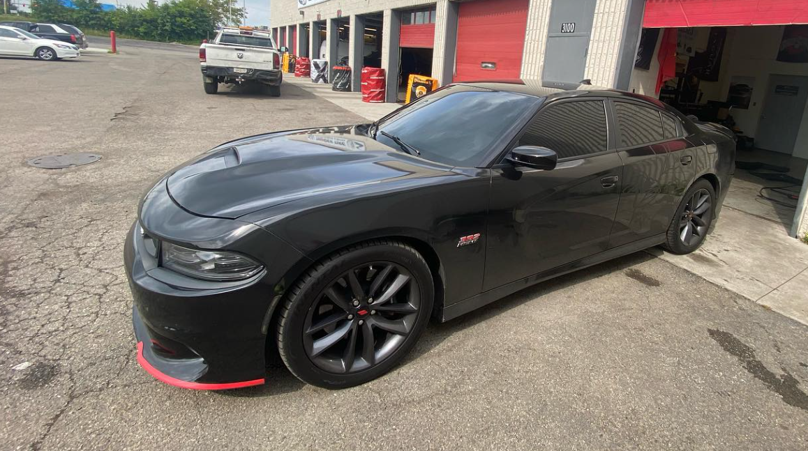 A silver car is parked in front of a building.