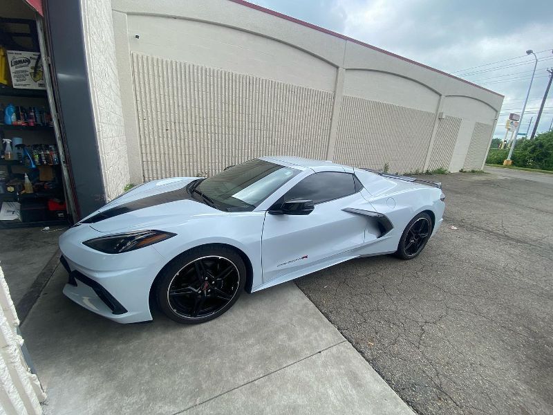 A white sports car is parked in front of a building.