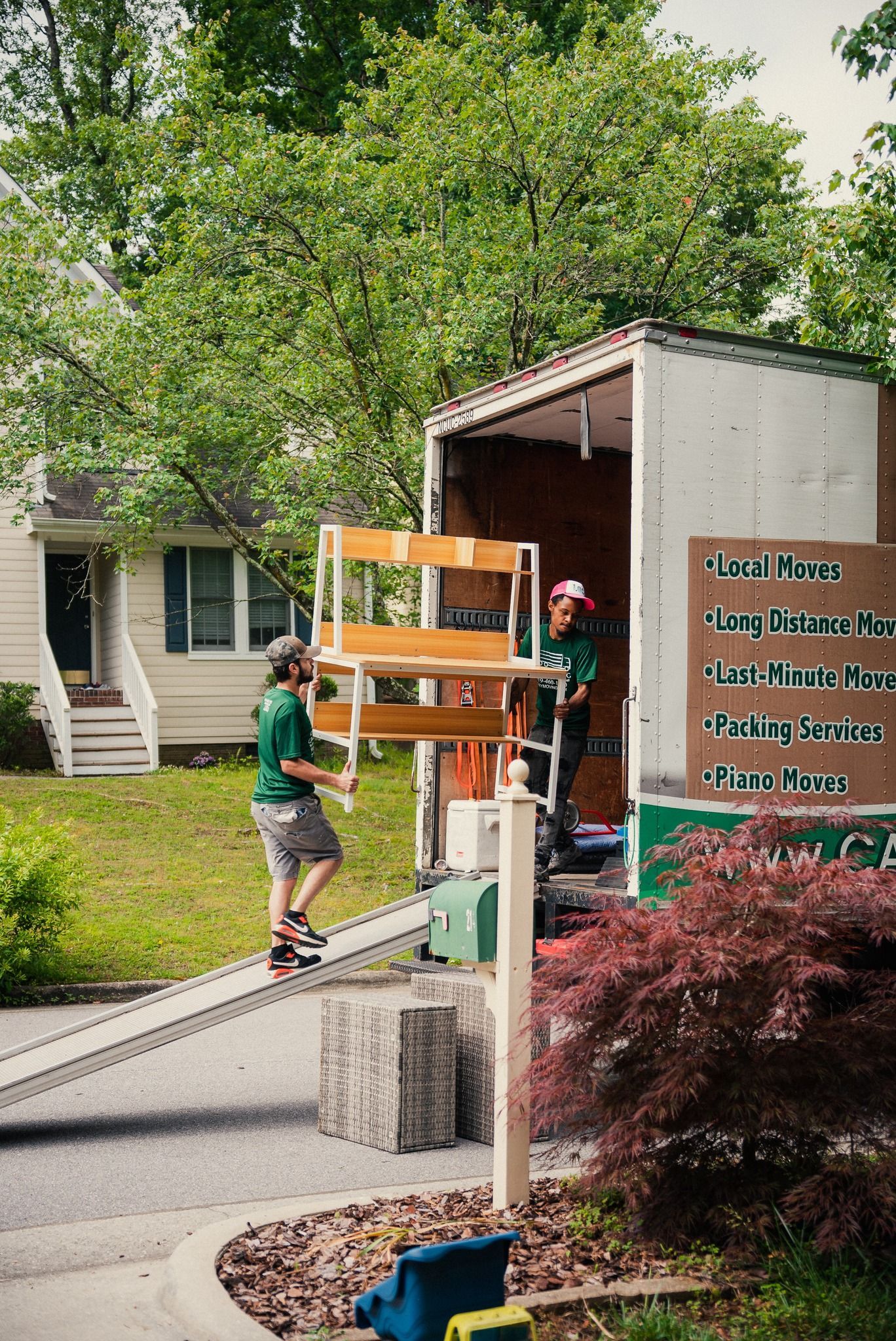 A man is loading a shelf into a moving truck.