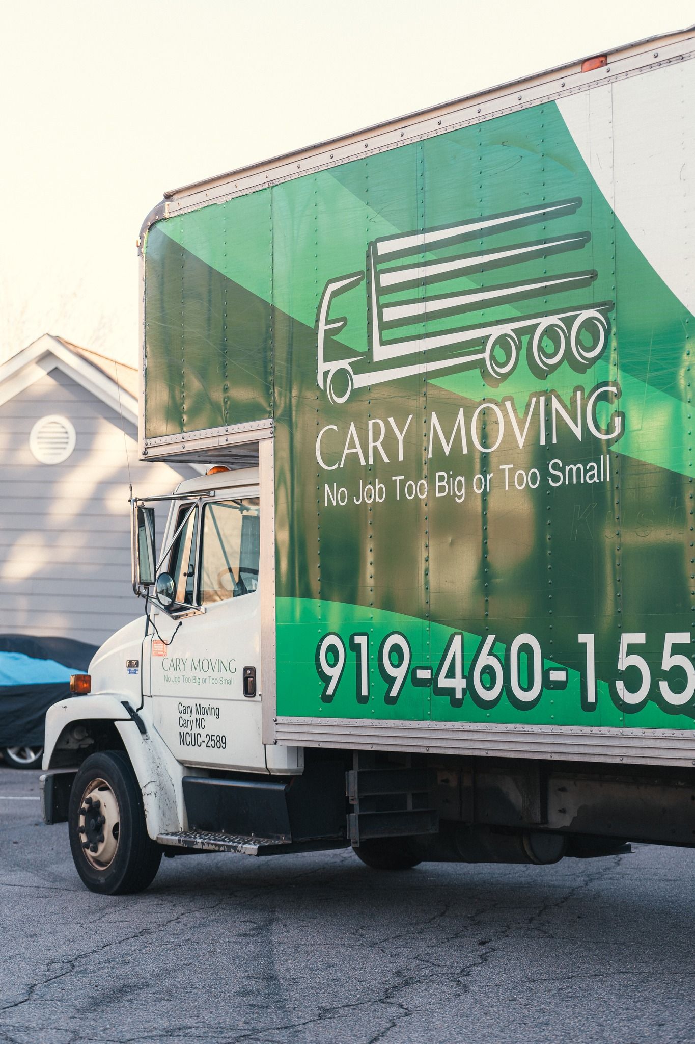 A cary moving truck is parked in front of a house.