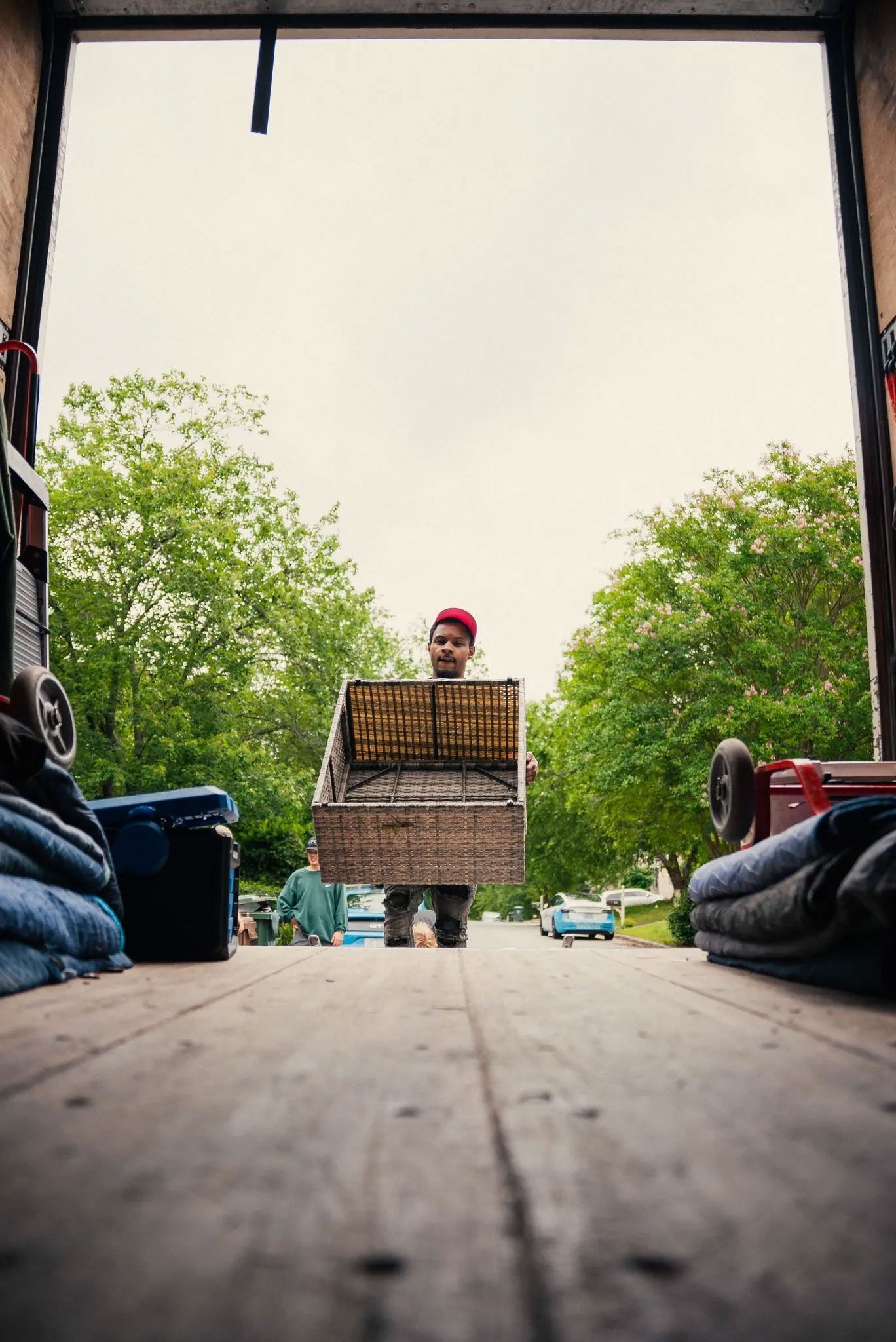 A man is carrying a large box in the back of a truck.