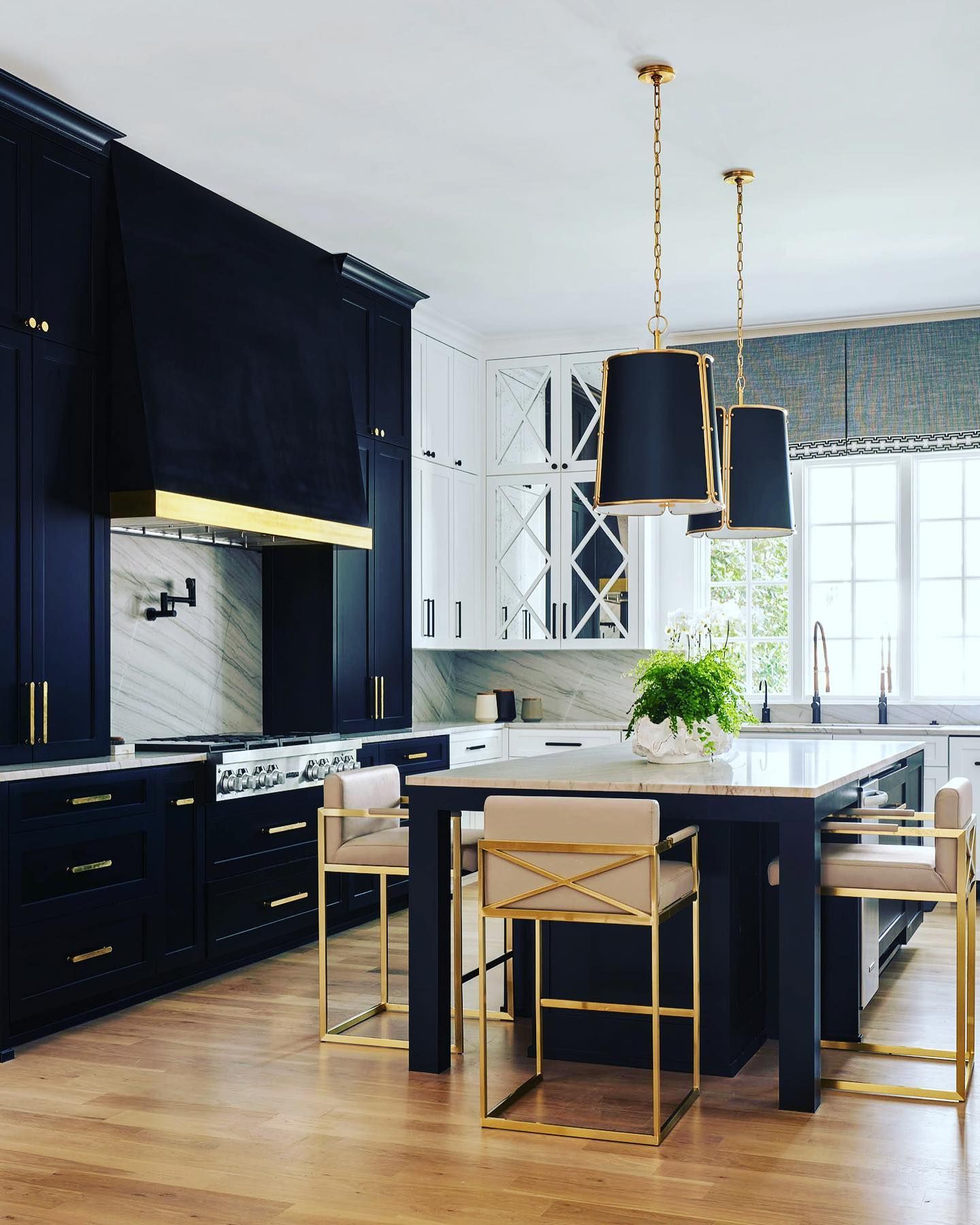 Elegant kitchen with navy cabinets, white accents, and gold fixtures.