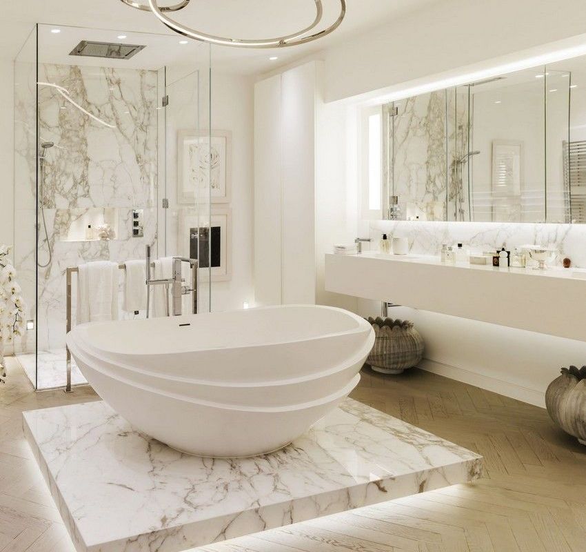 Luxurious white bathroom with marble accents, freestanding tub, and glass shower.