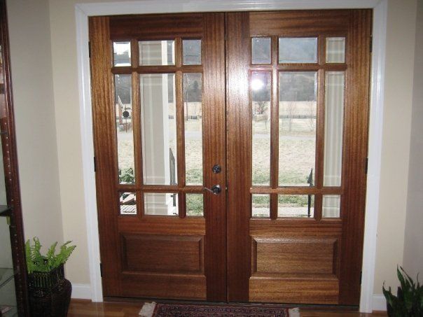 Wooden double front doors with glass panes and sidelights in a house entryway