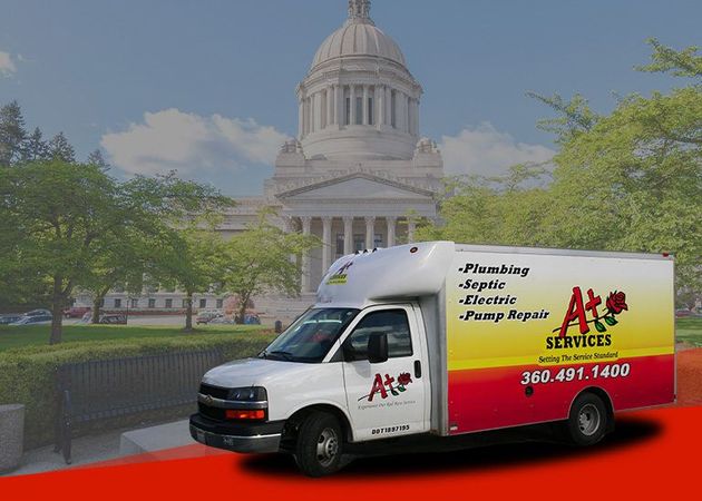 White AT's Services van with red-and-yellow logo in front of a domed capitol building