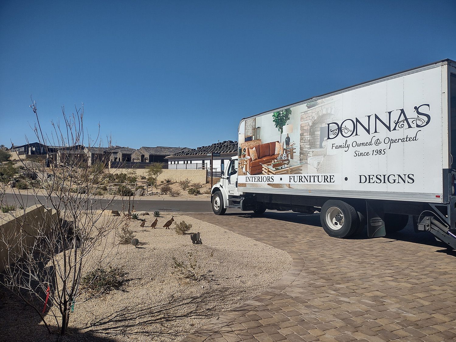 Truck from Bonnas Furniture parked in a residential area on a sunny day.