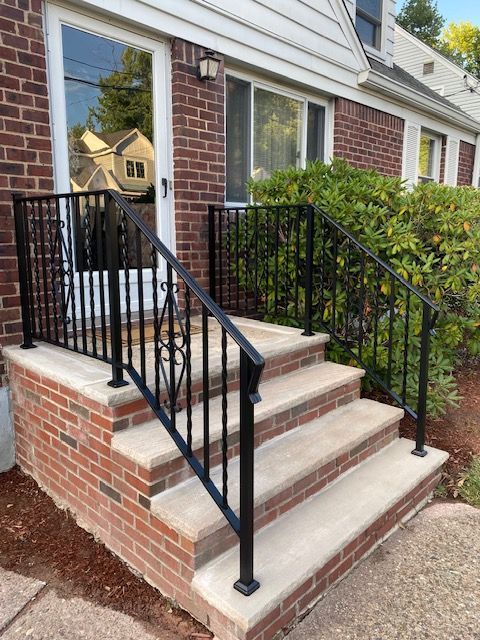 Brick front steps with black railings leading to a house entrance