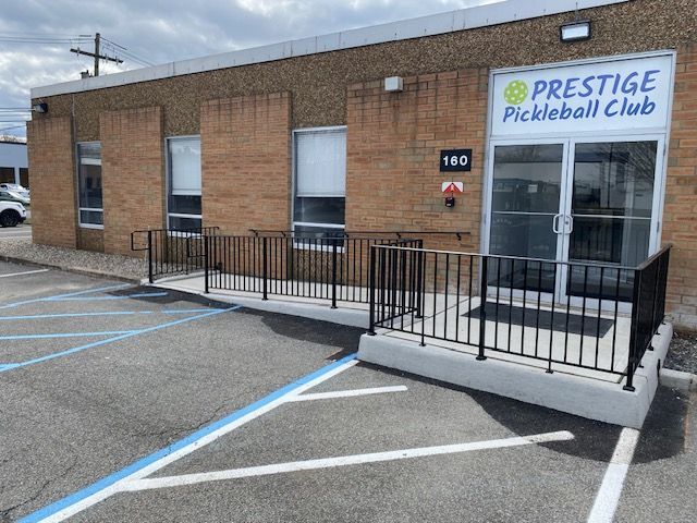 A brick building with a sign that says prestige pickleball club