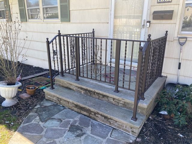 There is a wrought iron railing on the porch of a house.