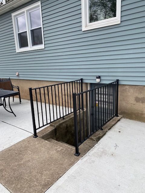 A blue house with a staircase leading to the basement.