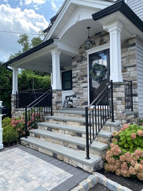 A stone house with stairs leading up to the front door