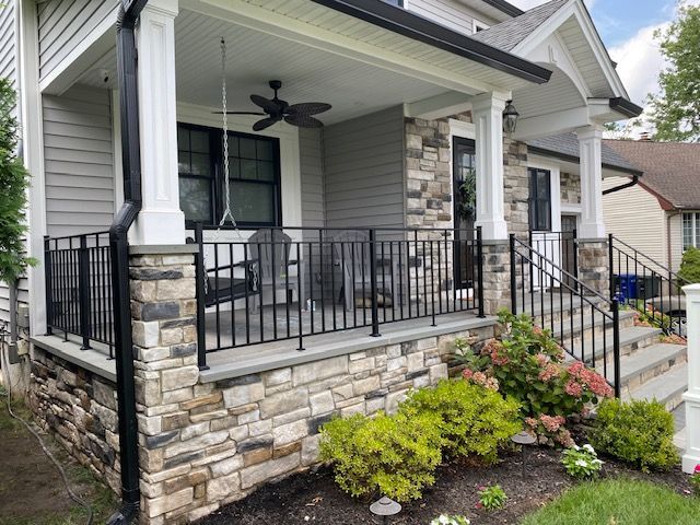 A house with a porch and a ceiling fan on it.