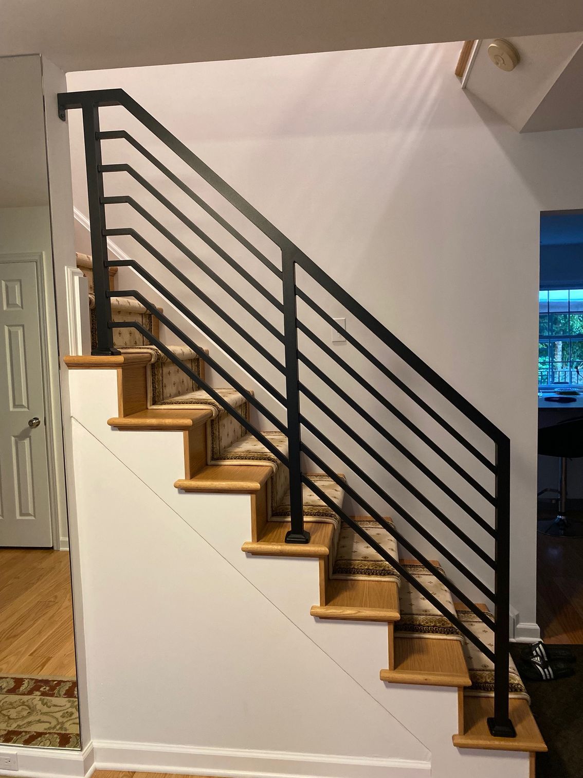 A staircase with a black railing and wooden steps
