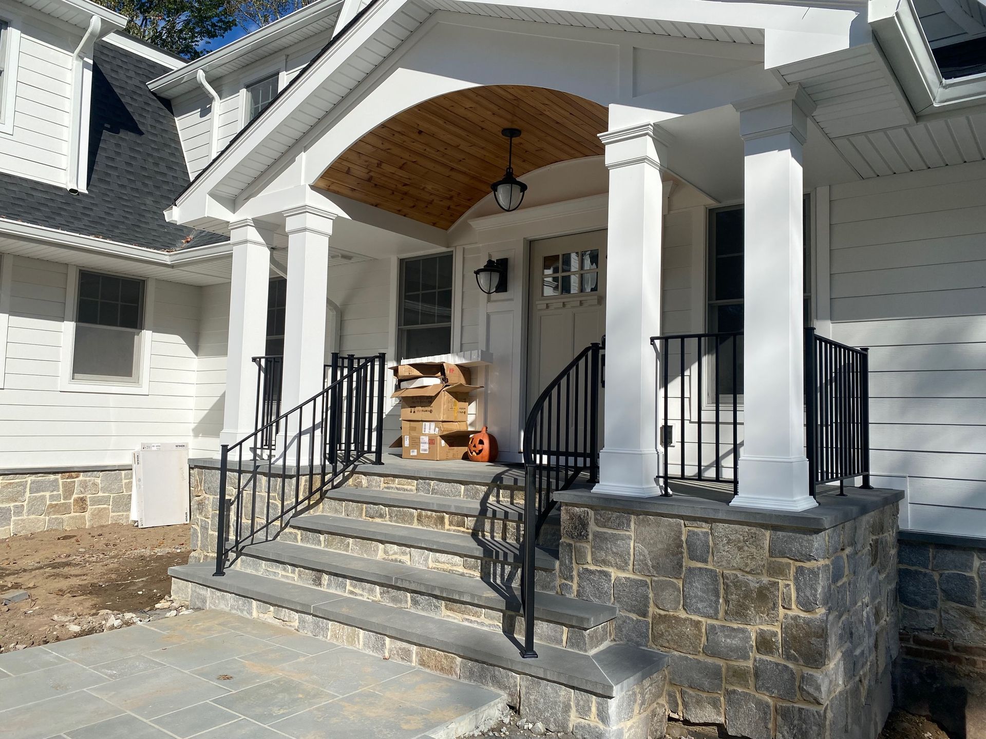 A white house with a porch and stairs