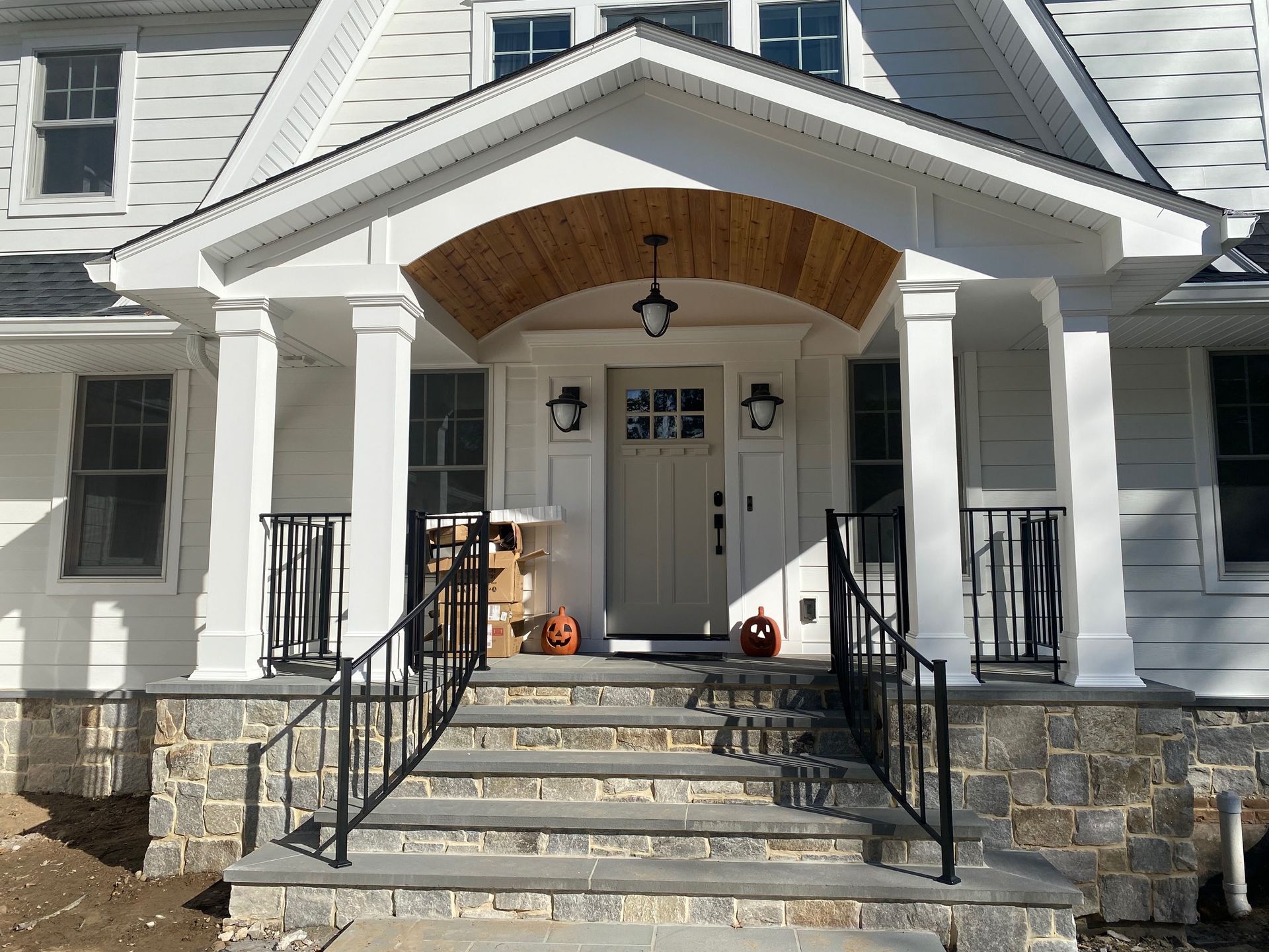 A white house with a porch and stairs