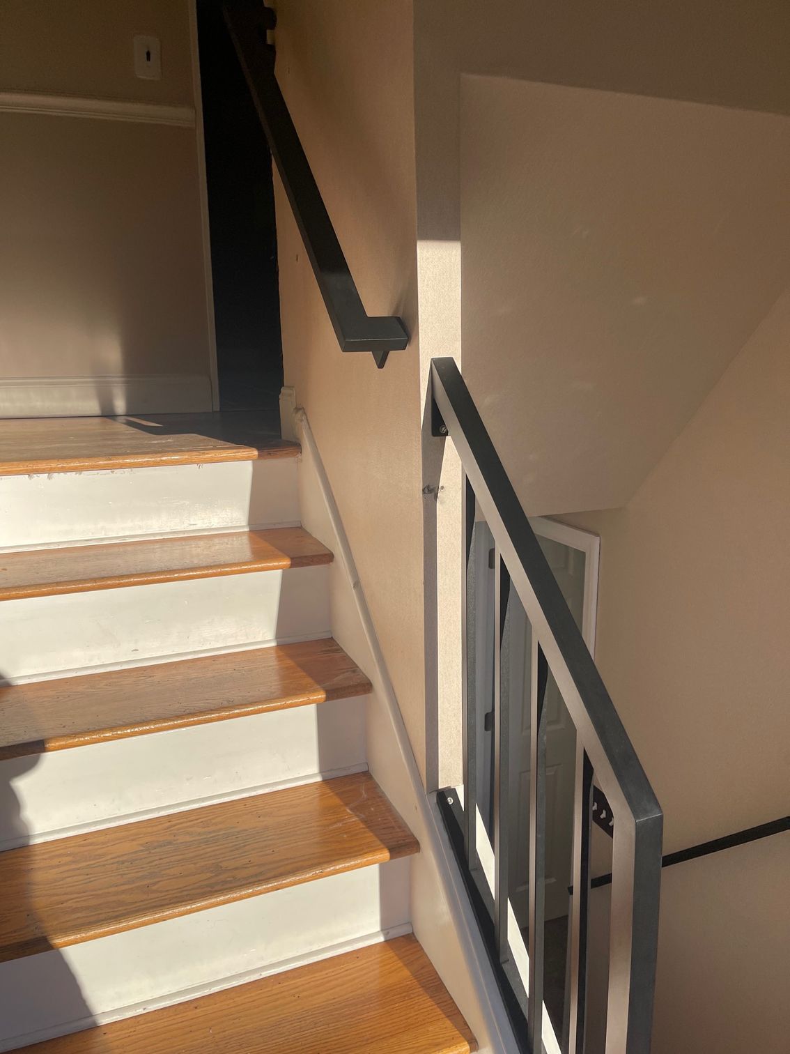 A staircase with wooden steps and a black railing