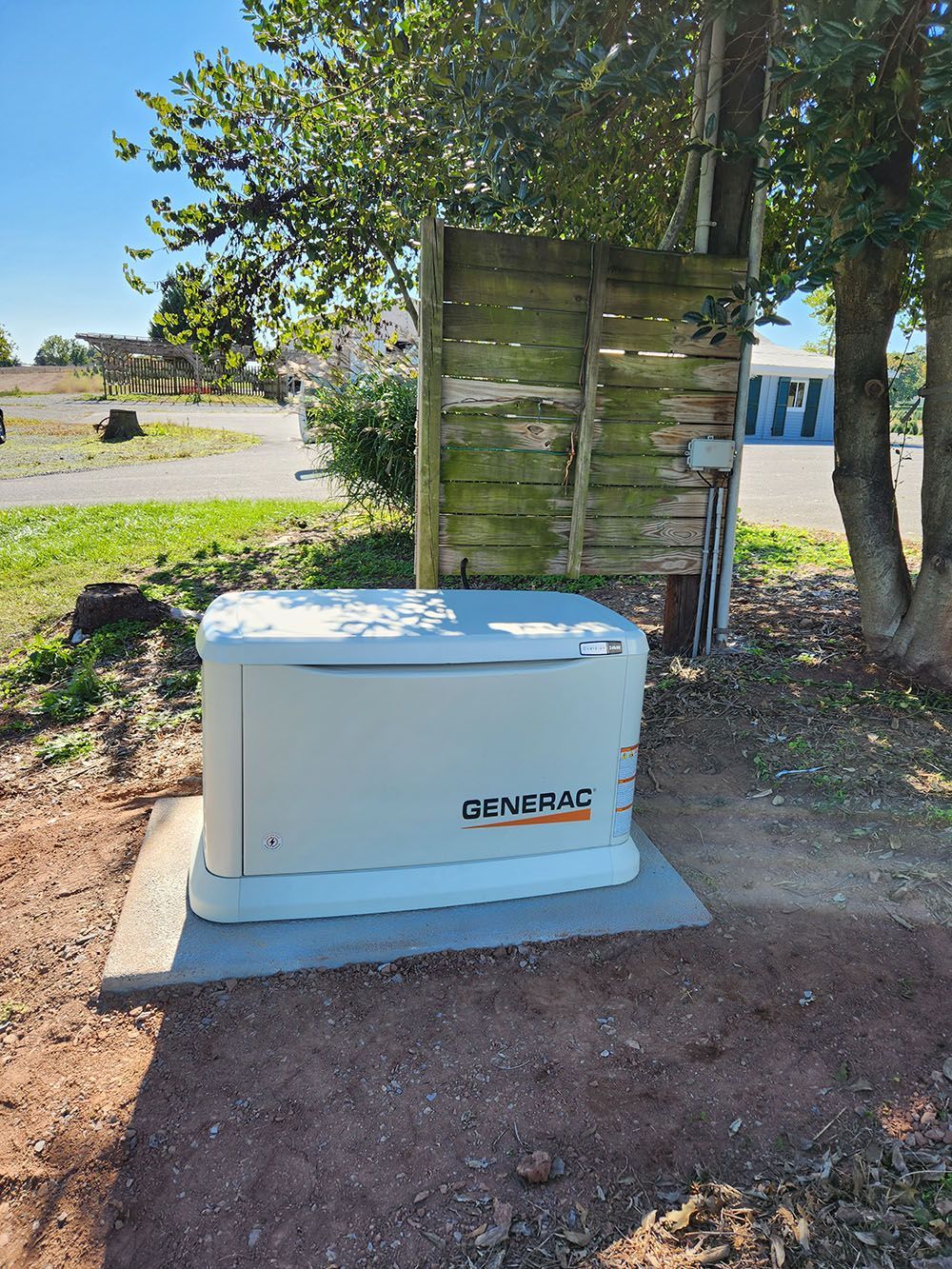 a generator is sitting on top of a concrete block next to a tree