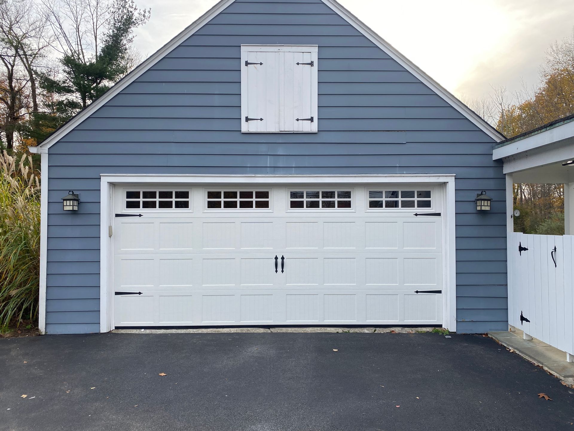 A blue garage with a white door and shutters