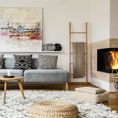 A living room with a couch , coffee table , rug and fireplace.