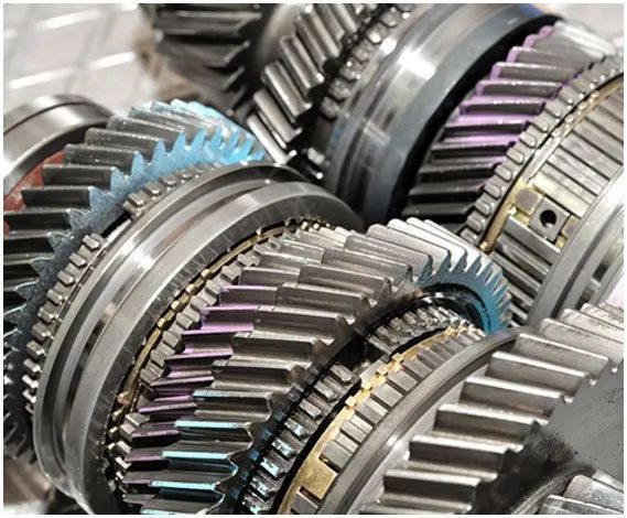 Close-up of shiny metal gears and transmission parts with blue and purple highlights