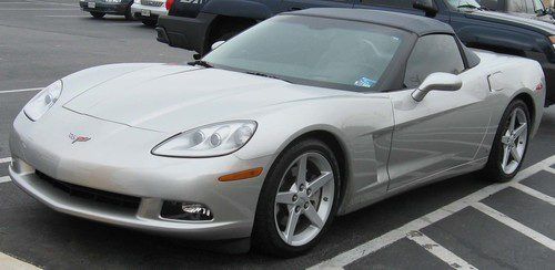 A silver sports car is parked in a parking lot.