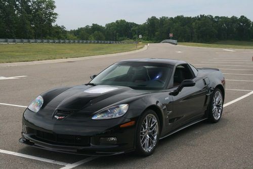 A black sports car is parked in a parking lot