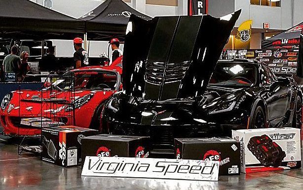 A group of cars are parked in a room with a sign that says virginia speed.
