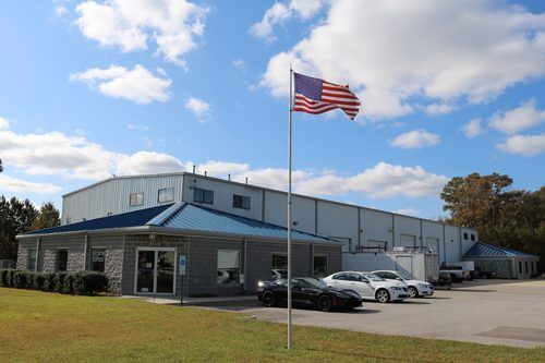 An american flag is flying in front of a large building.