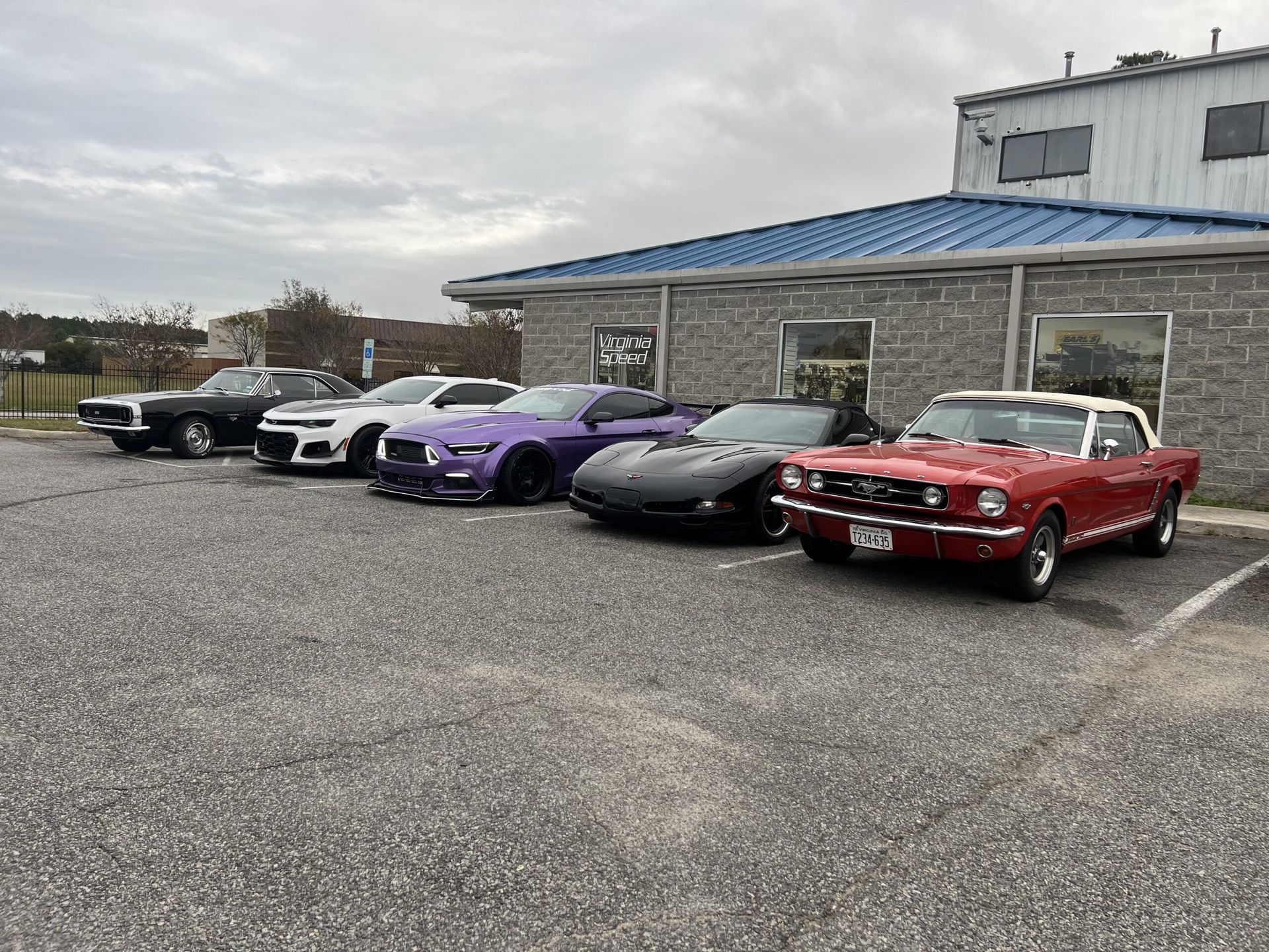 A row of cars are parked in front of a building.