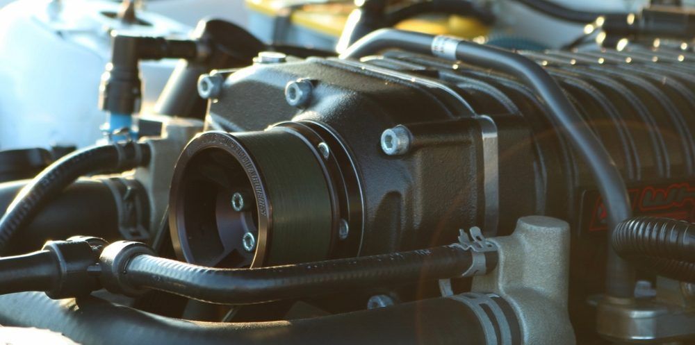 A close up of a car engine with a hose coming out of it
