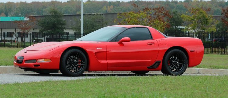 A red sports car is parked on the side of the road.