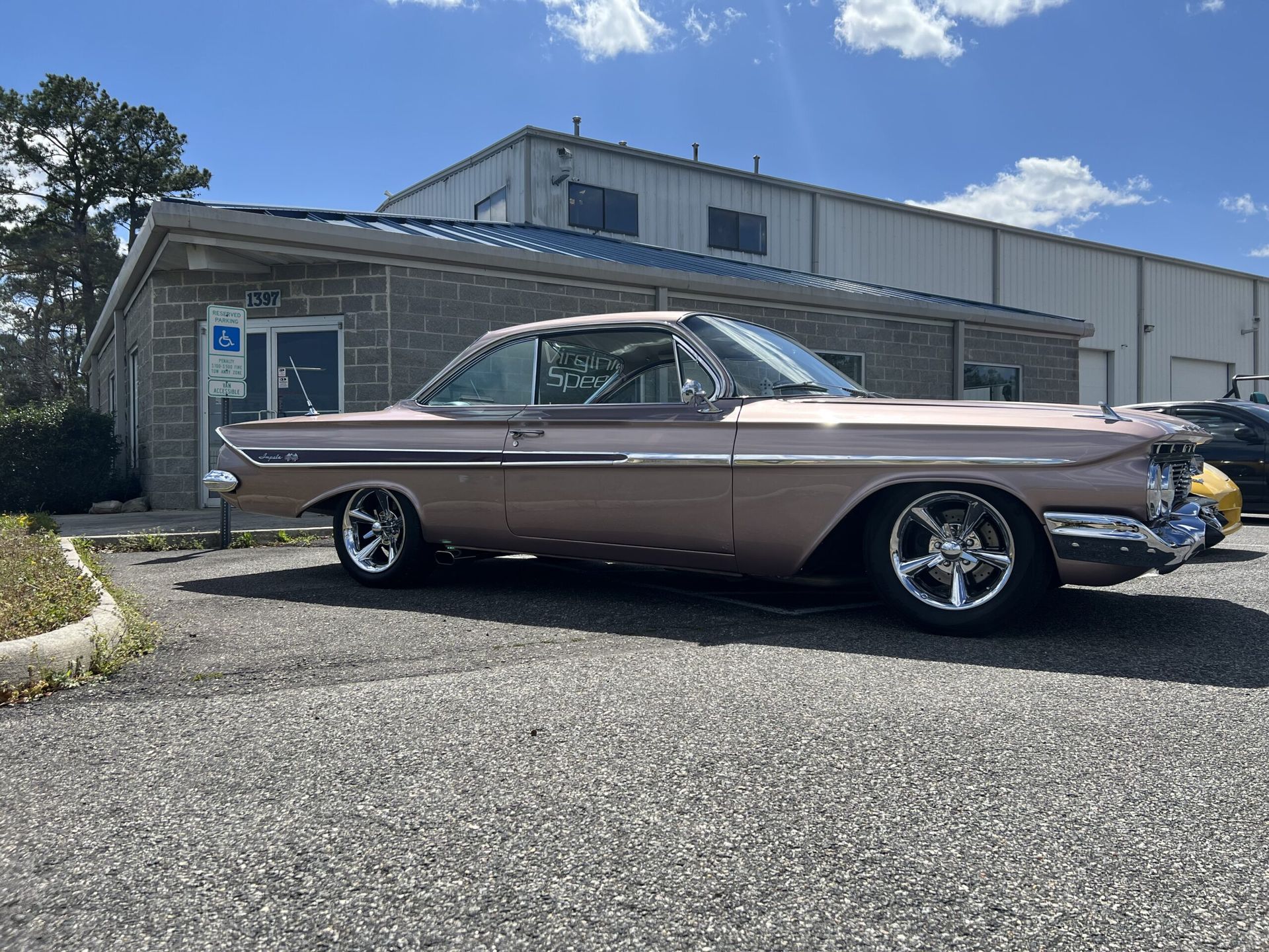 A pink car is parked in front of a building.