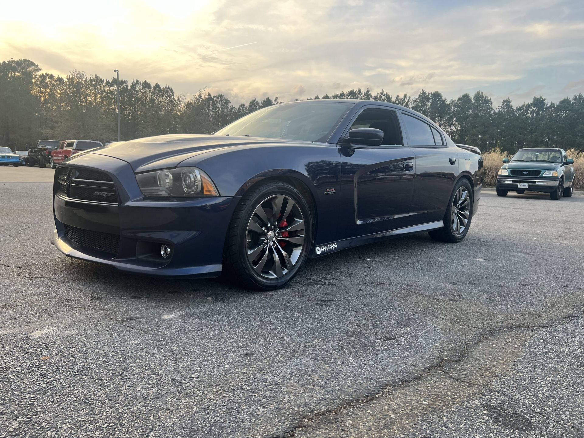 A blue dodge charger is parked in a parking lot.