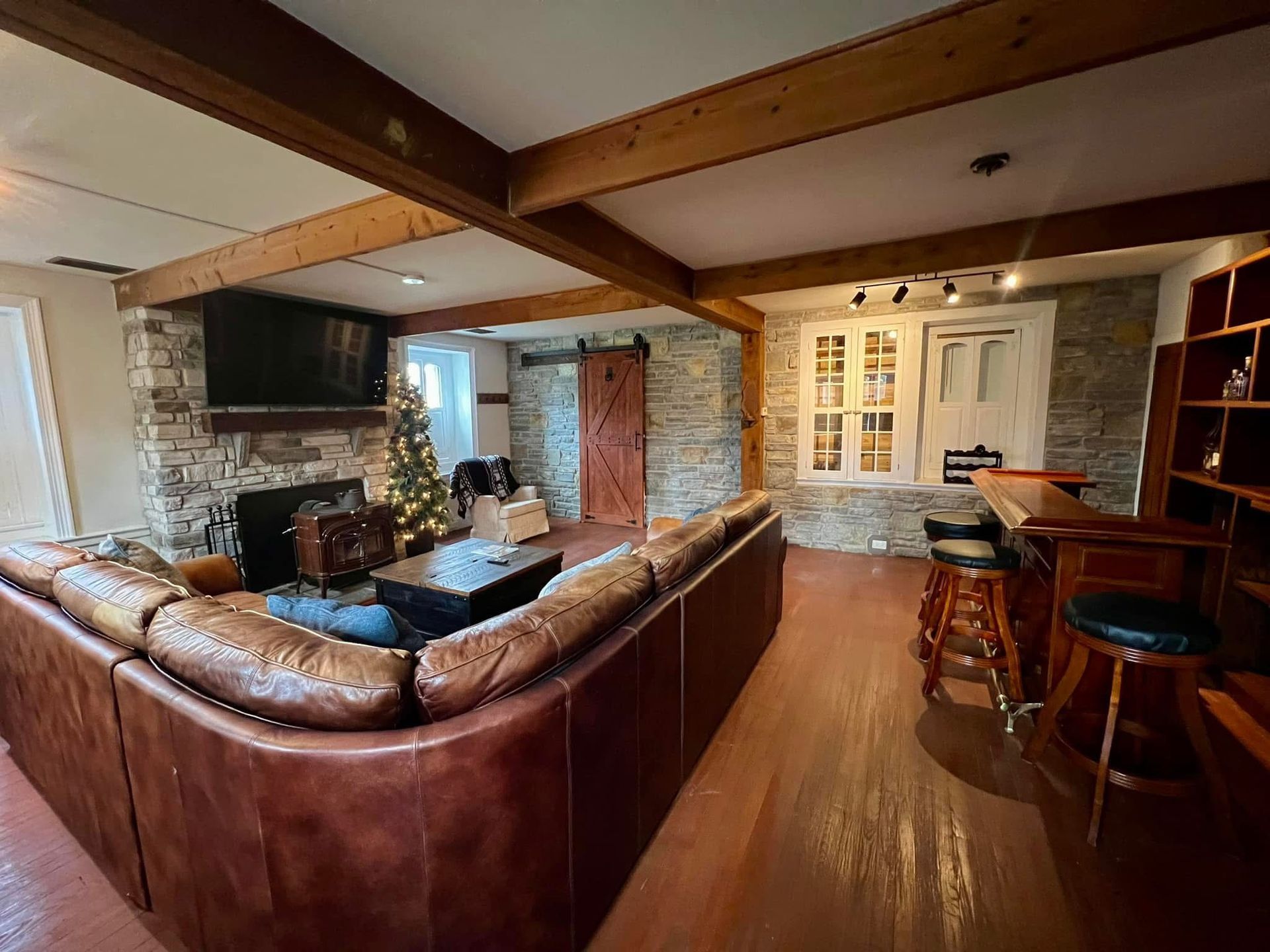A living room with a large sectional couch and a bar.