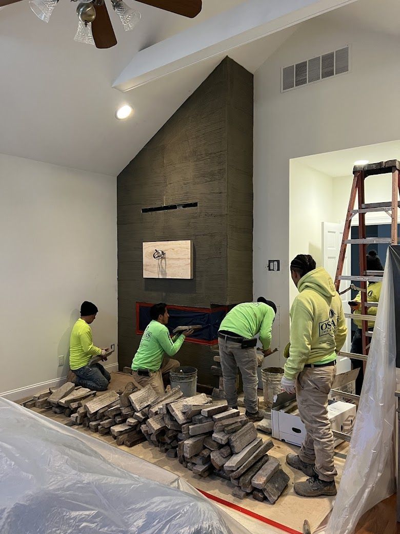 A group of men are working on a fireplace in a living room.
