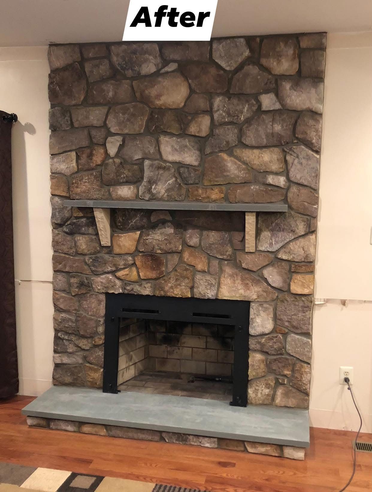 A stone fireplace in a living room with a sign above it that says after.
