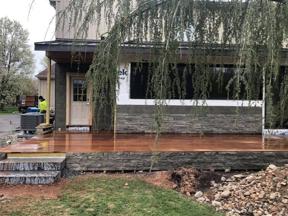 A wooden deck is being built in front of a house.