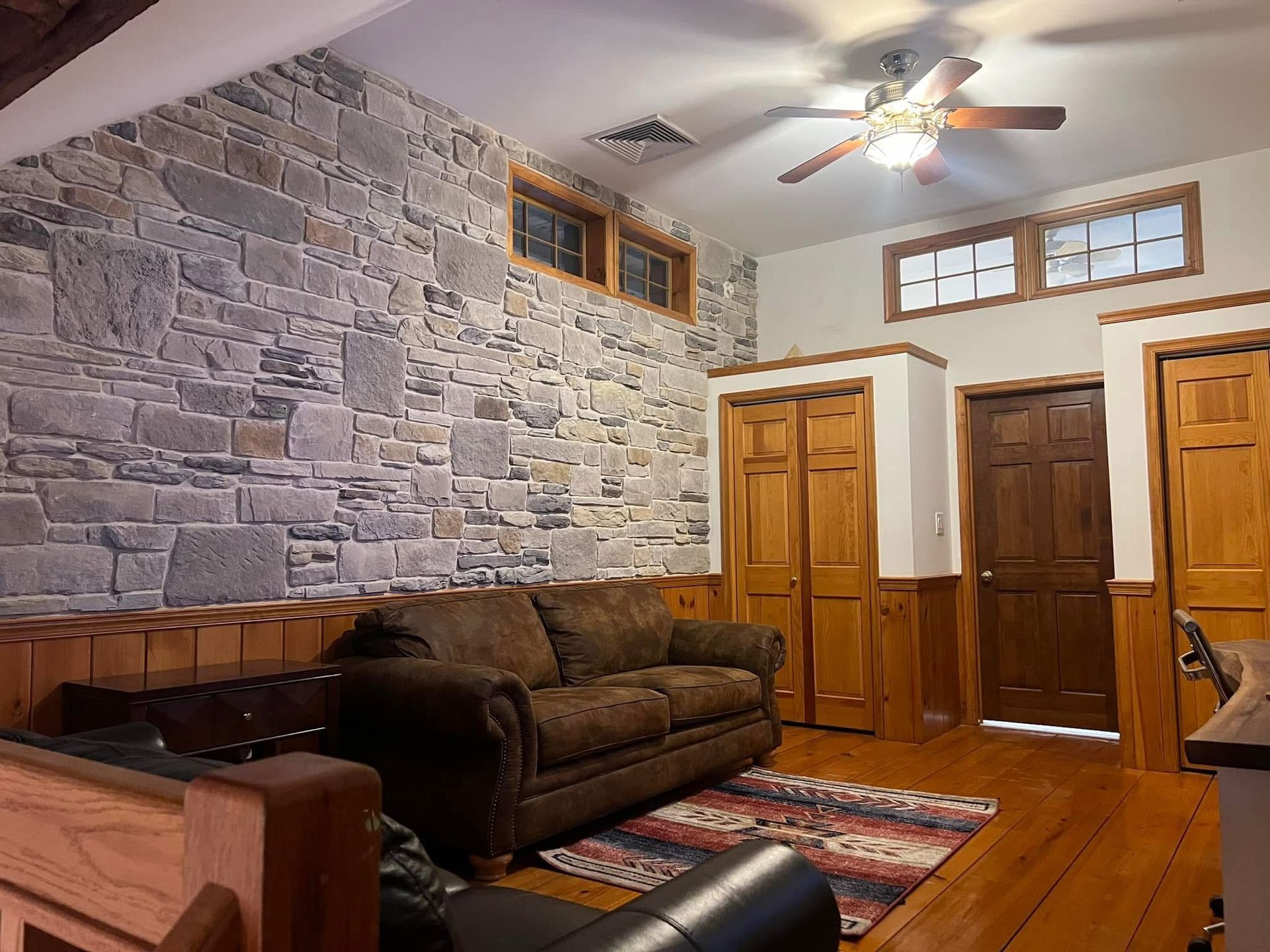 A living room with a couch and a ceiling fan