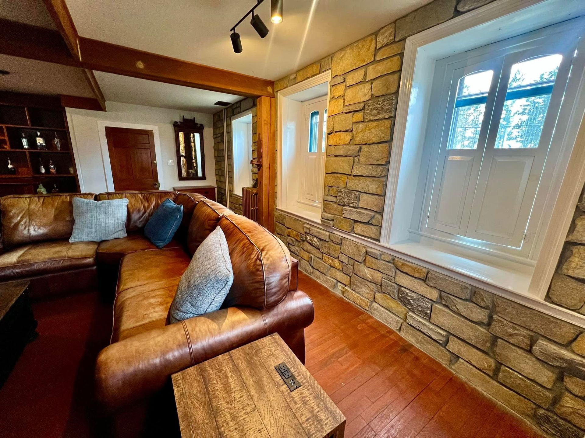 A living room with a couch , table , and windows.