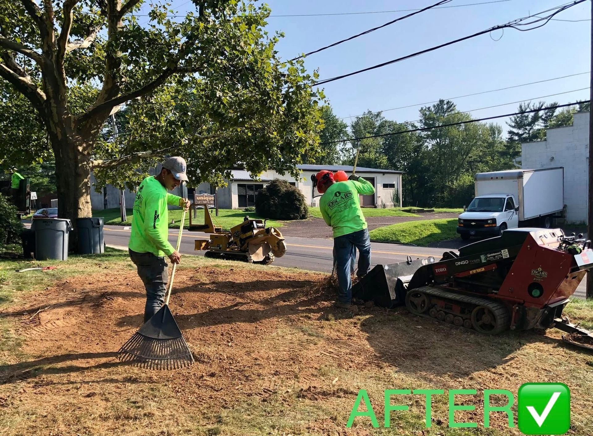 Two men are working on a stump grinder in a yard.