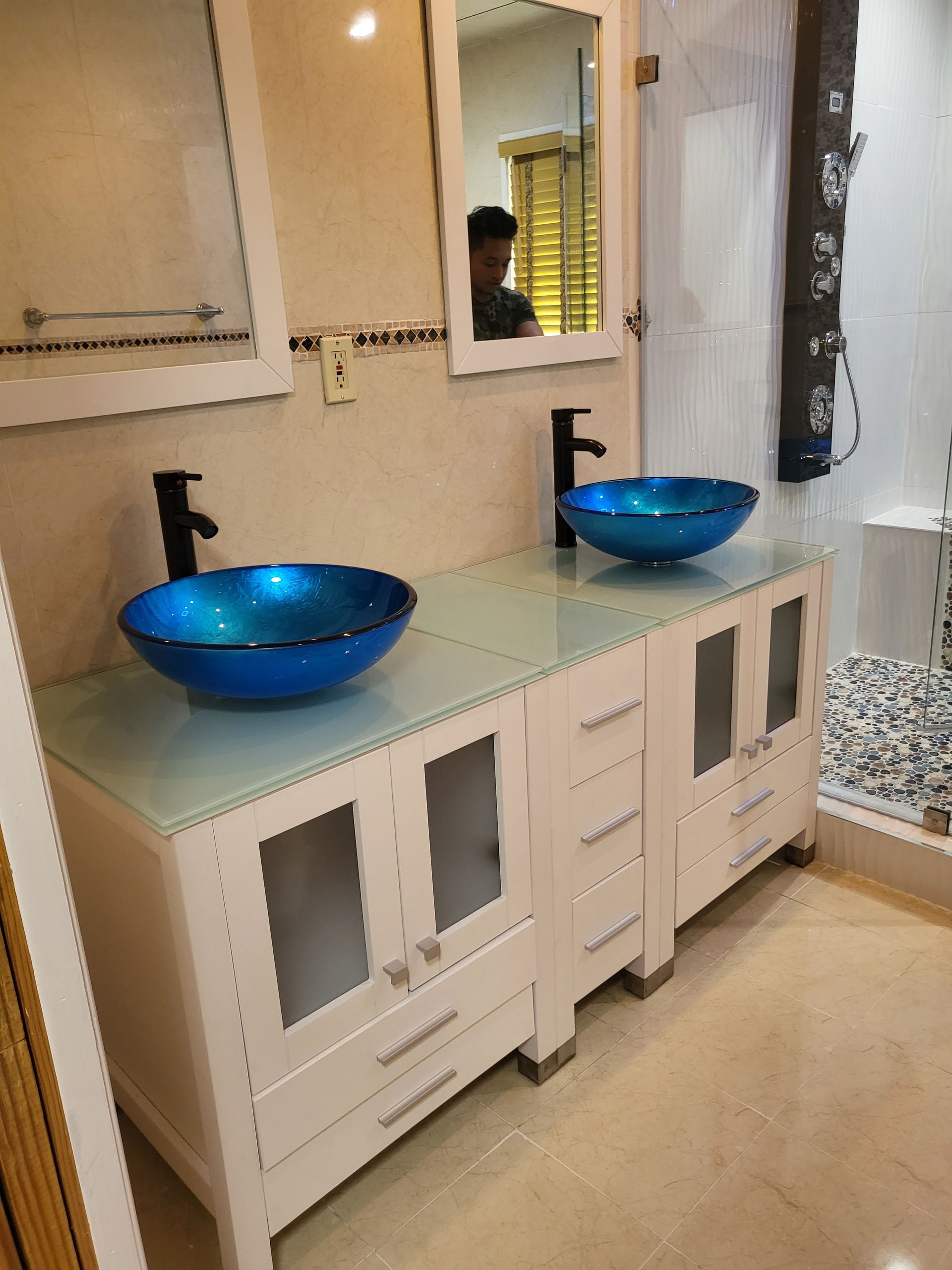 a bathroom with two blue sinks and two mirrors