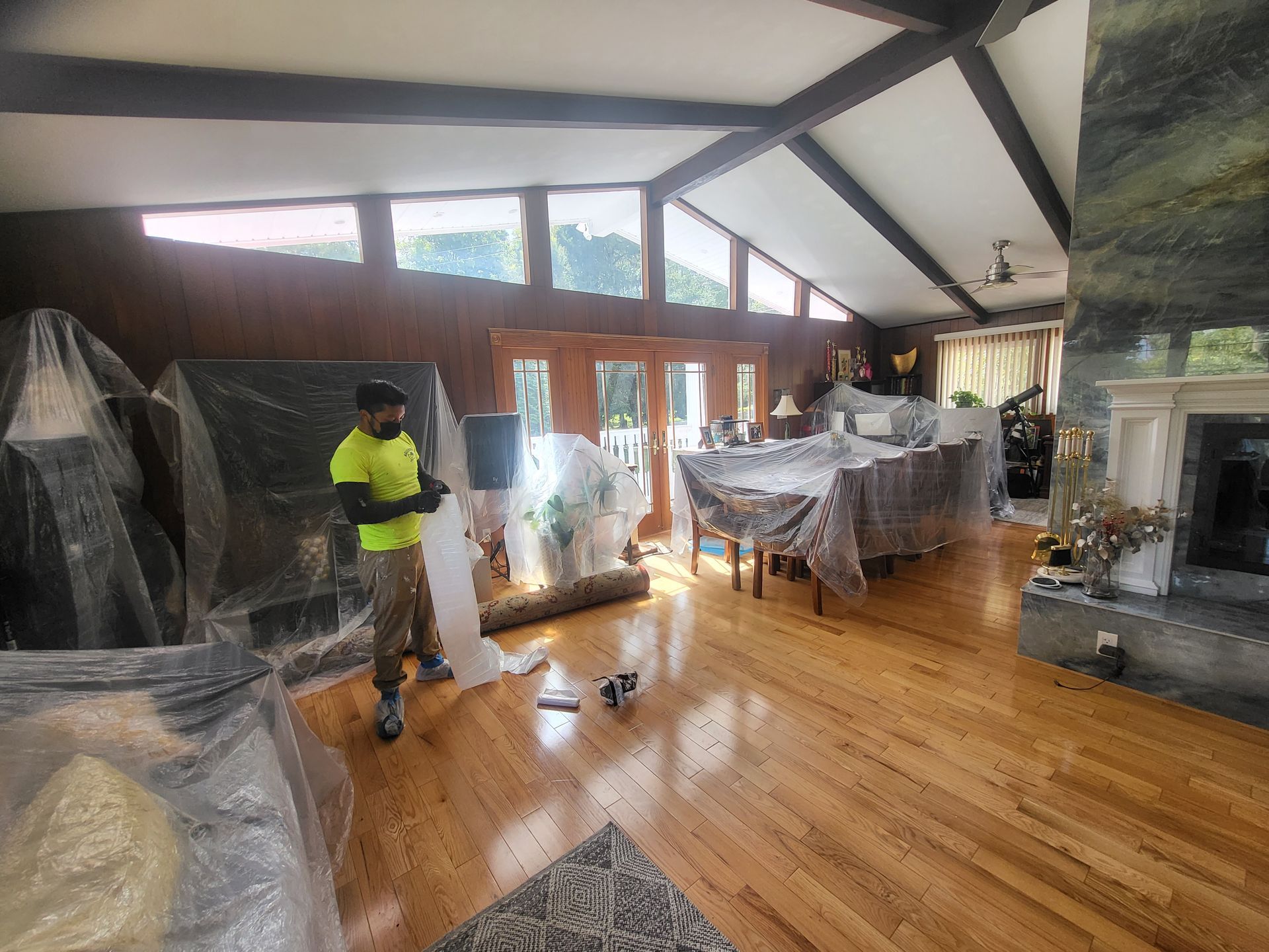 a man is standing in a living room covered in plastic wrap