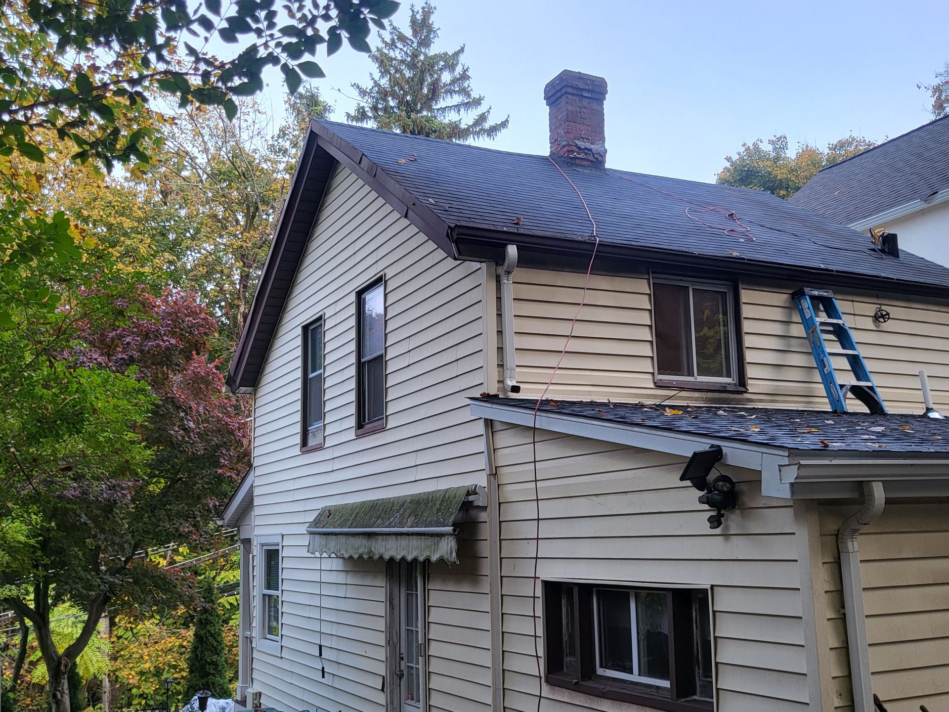 a house with a ladder on the roof is being remodeled